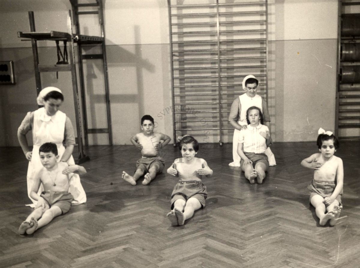 Istituto Ortopedico "Luigi Spolverini" di Ariccia - Bambini che effettuano ginnastica segmentaria per la spalla seguiti da assistenti