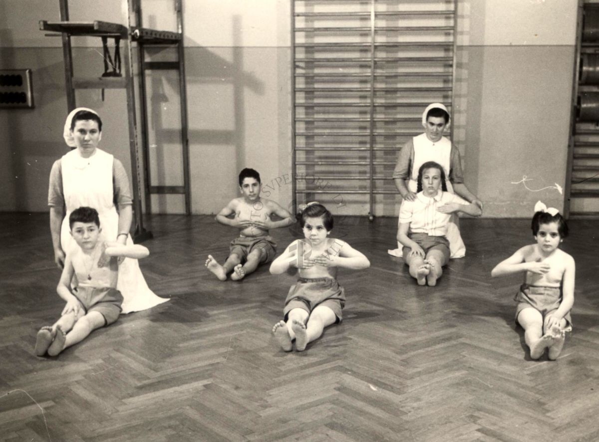 Istituto Ortopedico "Luigi Spolverini" di Ariccia - Bambini che effettuano ginnastica segmentaria per la spalla seguiti da assistenti