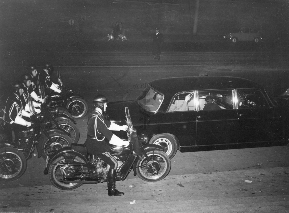 Il principe dello Yemen e il suo seguito in automobile, scortati da una pattuglia di motociclisti, davanti all'ingresso principale dell'Istituto