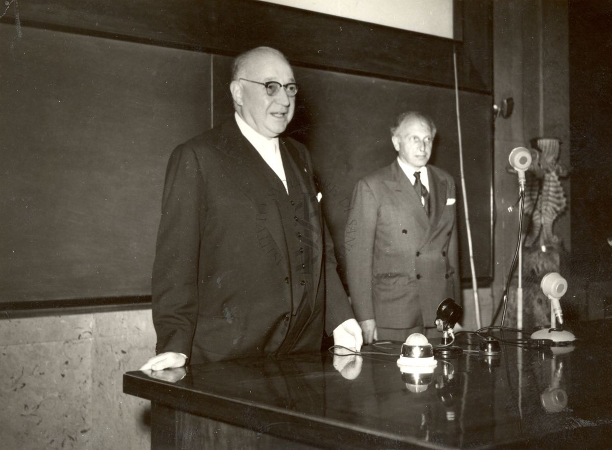 Il Prof. Marotta accanto il relatore Prof. Neuberger dietro la scrivania dell'Aula Magna