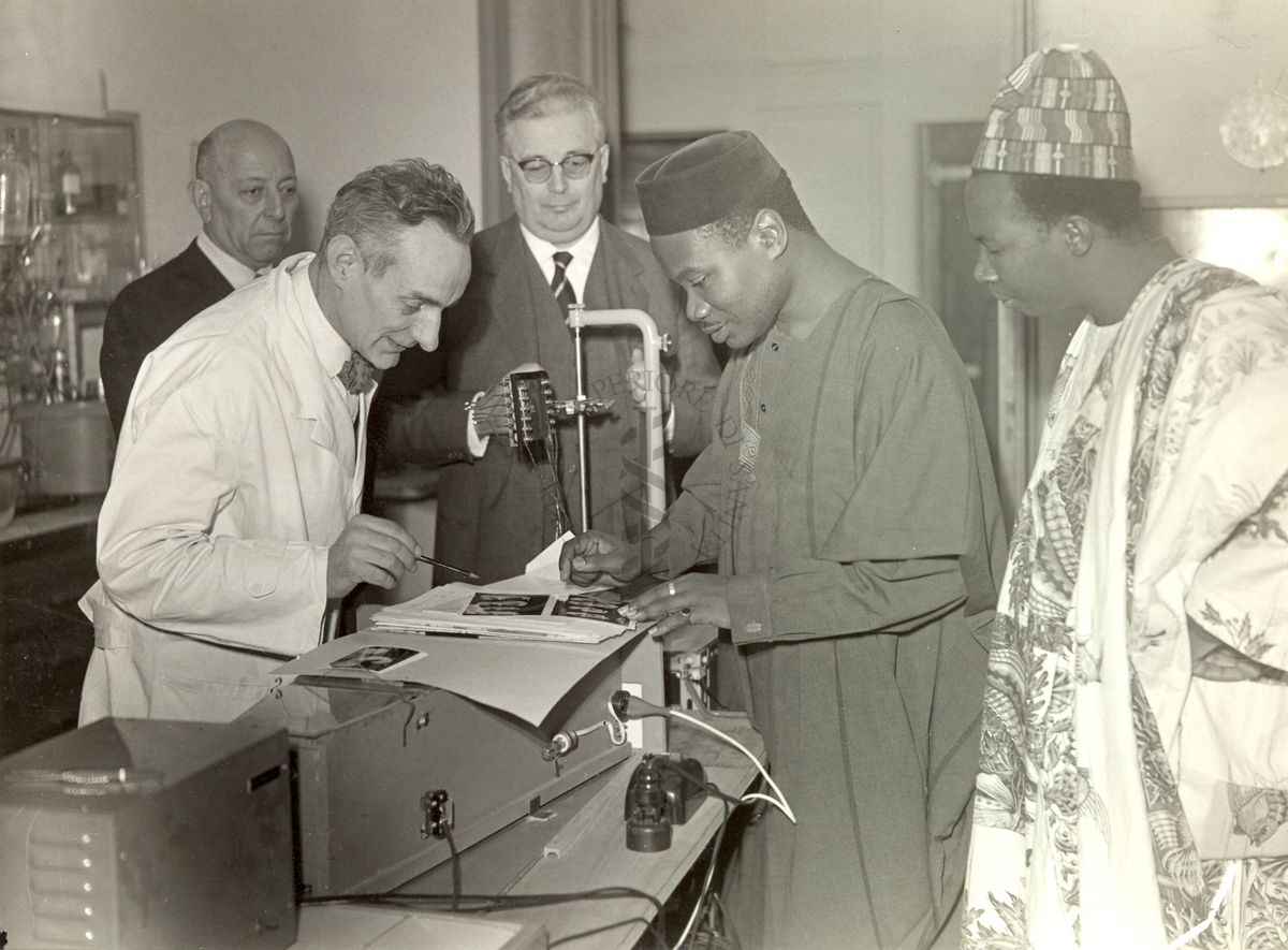 Il Prof. Daniel Bovet (con il camice a sinistra) illustra dei risultati di esperimenti al Ministro della Sanità della Nigeria, Dr. Moses Adekoyejo Majekodunmi; al centro il Prof. Giordano Giacomello
