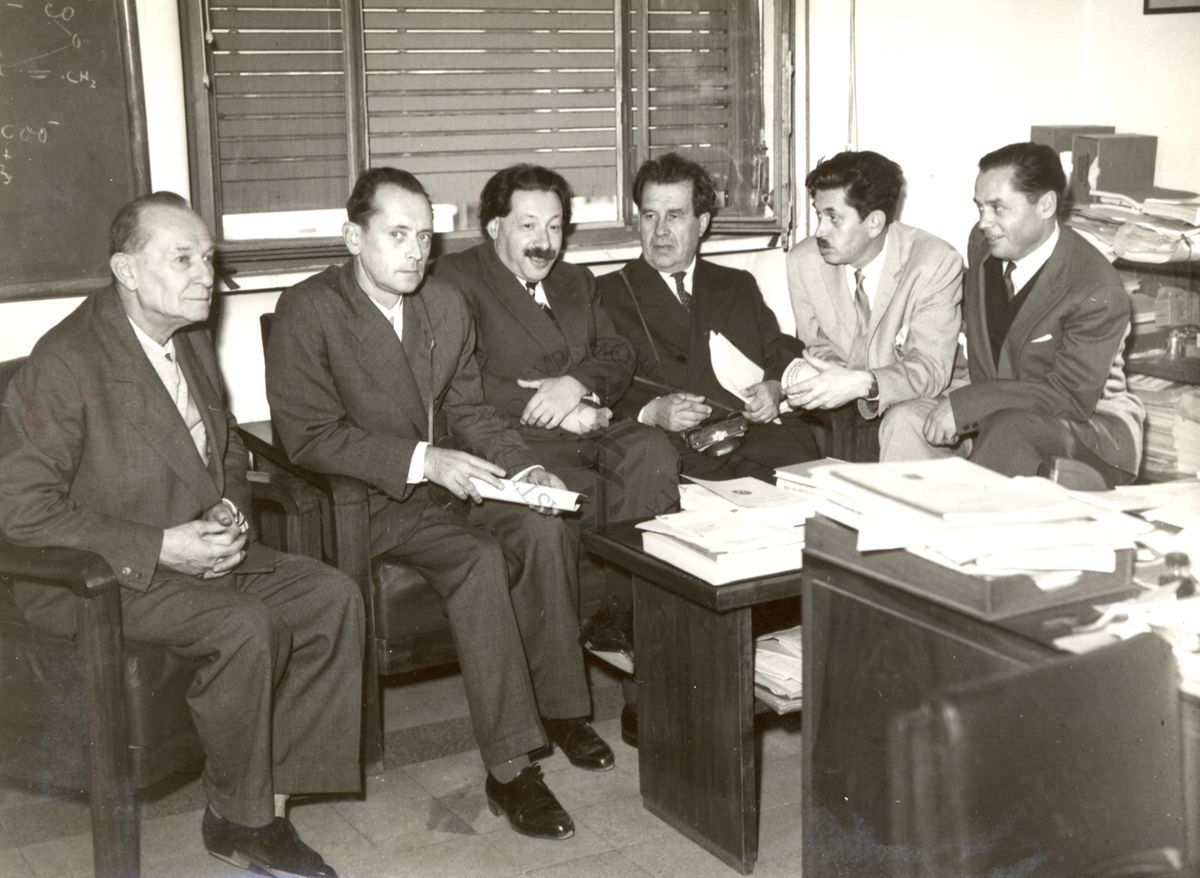 Il gruppo degli studiosi russi in visita all'Istituto Superiore di Sanità seduto in un ufficio insieme al Prof. Ernst Boris Chain (terzo da sinistra) e il Dott. Massimo Pantaleoni (primo a sinistra)