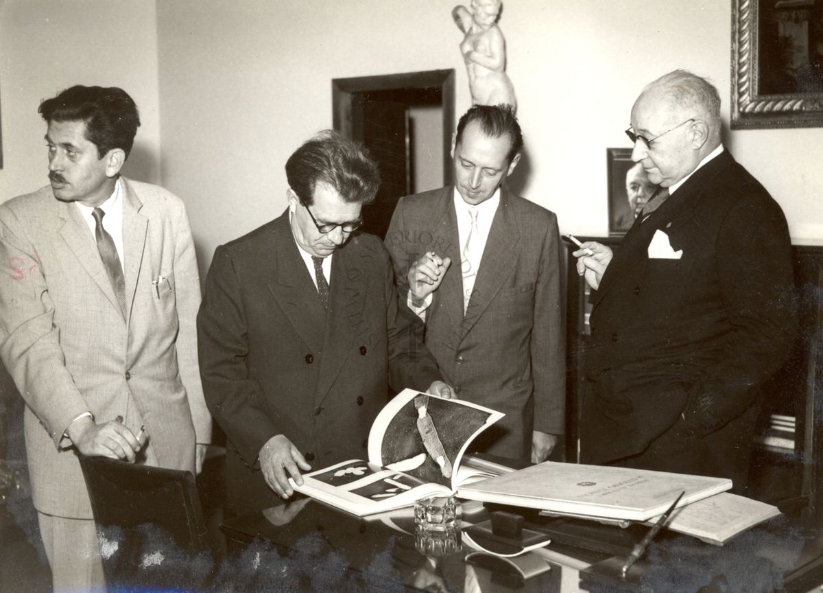 Tre degli studiosi russi in visita all'Istituto Superiore di Sanità visionano un volume accanto al Prof. Domenico Marotta (a destra) in uno degli uffici della direzione
