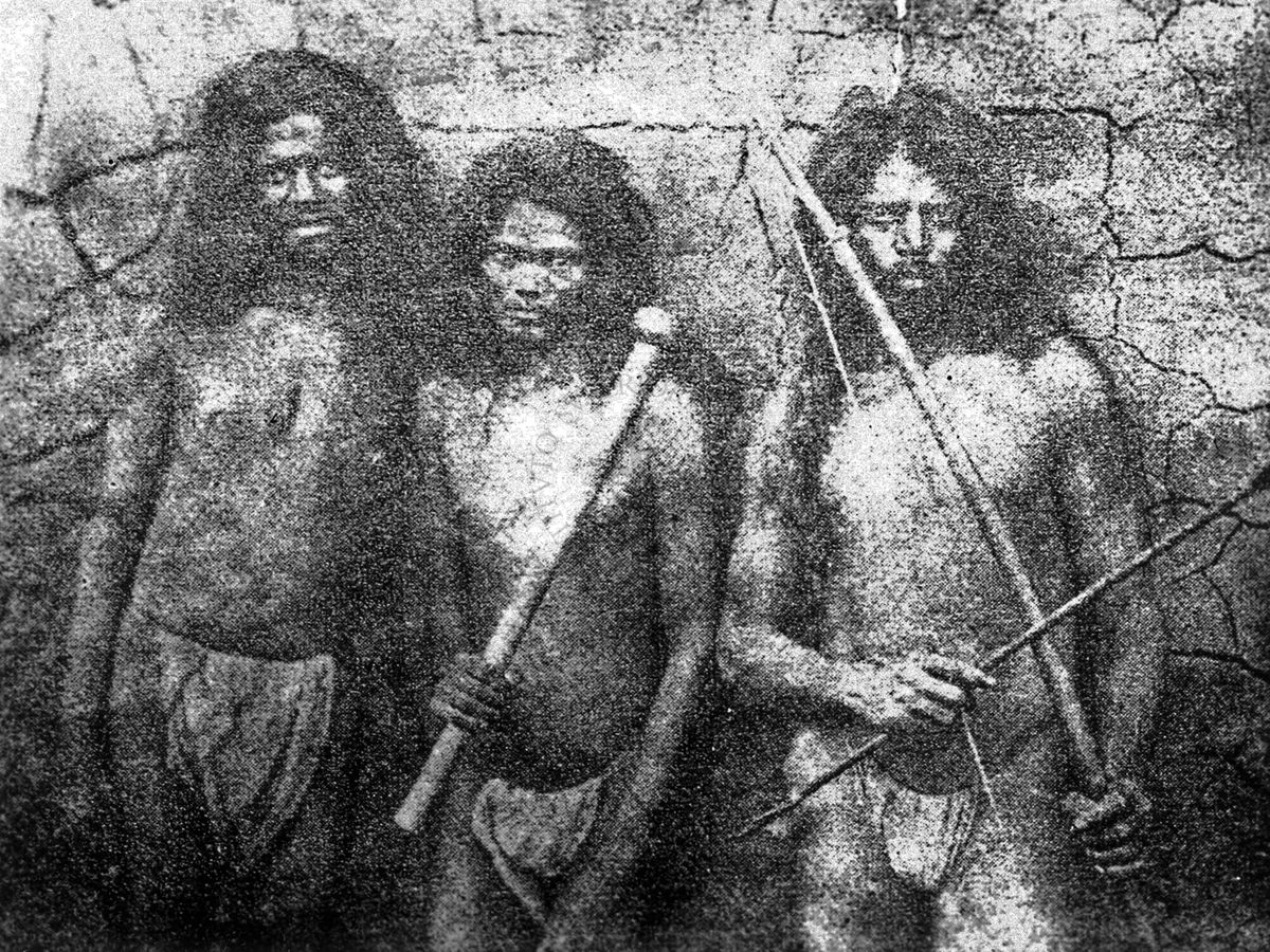 Nella foto sono ritratti tre indigeni due dei quali hanno un bastone ed un arco