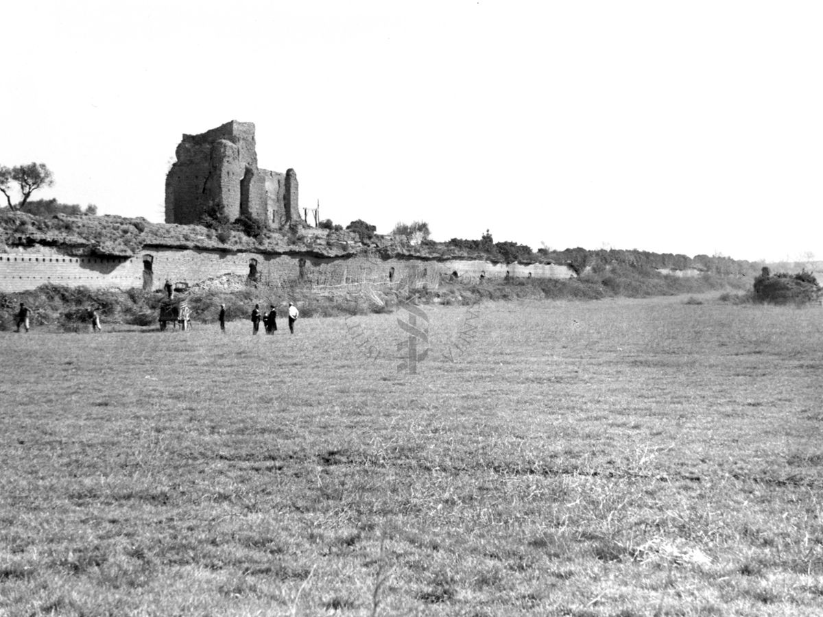 Vista del Circo Massenzio con ruderi di una torre sullo sfondo e delle persone