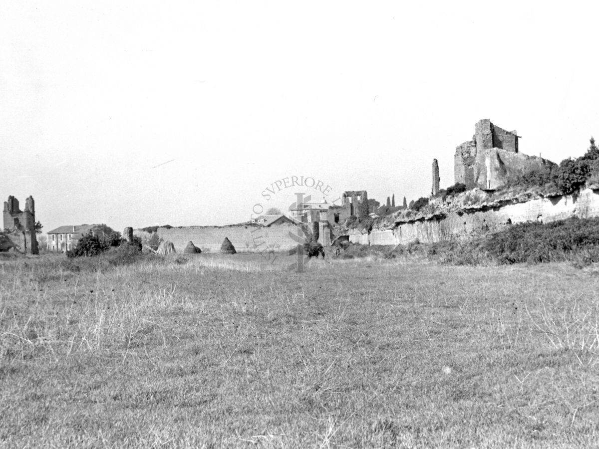 Vista del Circo Massenzio con ruderi di una torre e del muro e in lontananza una casa