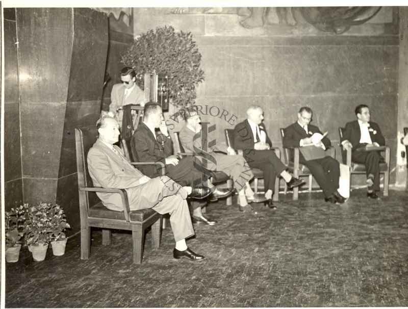 Foto di alcuni partecipanti al Congresso su sedie disposte in semicerchio all'interno dell'Aula Magna della Città Universitaria di Roma