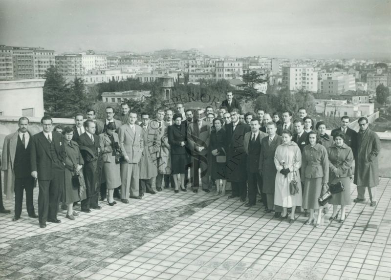 Foto di gruppo sulla terrazza dell'edificio principale dell'Istituto Superiore di Sanità con panorama sulla città in direzione di Piazza Bologna. Al centro il Dott. Pantaleoni