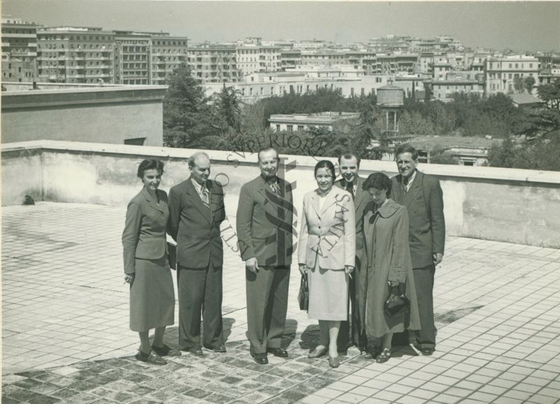 Ripresa dall'alto del gruppo di medici russi in visita, composto di quattro uomini e tre donne, su una terrazza dell'Istituto Superiore di Sanità con veduta di Roma sullo sfondo