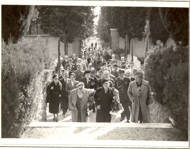 Un gruppo di persone si avviano nel cimitero