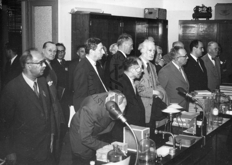 Parte del gruppo dei delegati dell'UNESCO in visita all'Istituto Superiore di Sanità ripreso all'interno delle stanze da lavoro. Si riconosce nella foto il Dott. Massimo Pantaleoni, davanti alla porta vetri con lo sguardo rivolto verso la macchina fotografica.