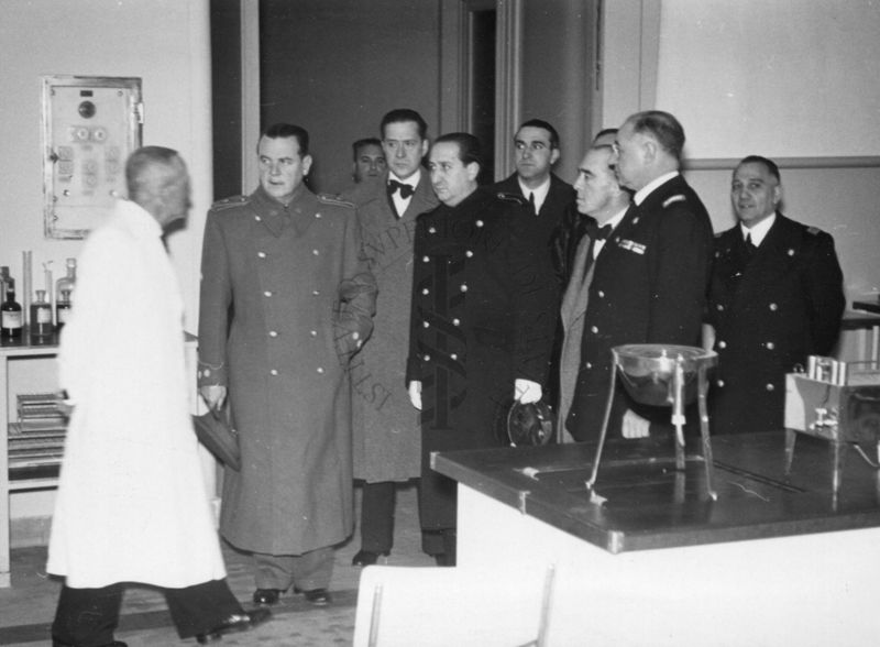 Il Prof. Palanca insieme al Prof. Prof. Domenico Marotta (penultimo a destra) e ad altre persone in un locale dell'Istituto Superiore di Sanità allestito con vetreria da laboratorio.