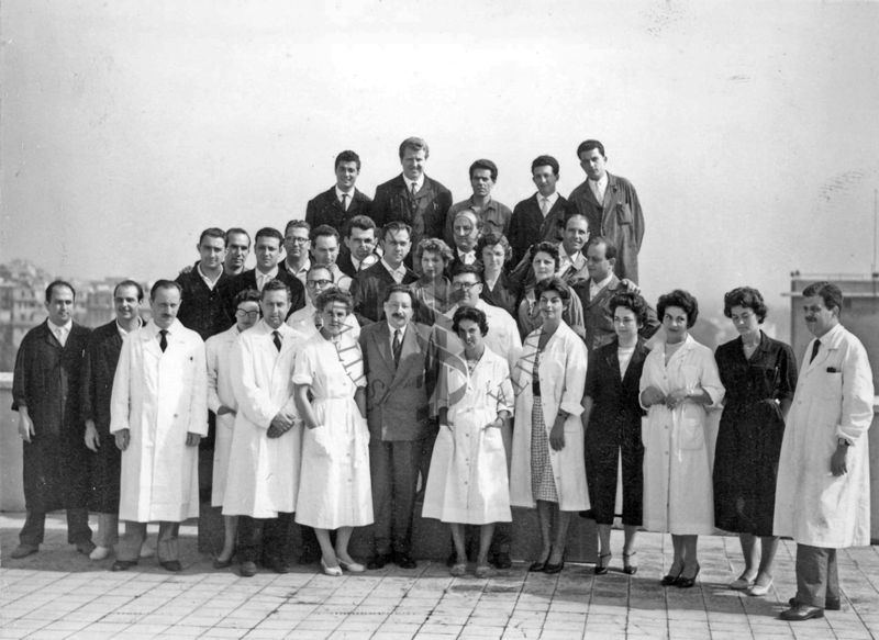 Foto di gruppo all'esterno dell'Istituto Superiore di Sanità, sulla terrazza dell'edificio centrale, con al centro il Prof. Ernst Boris Chain