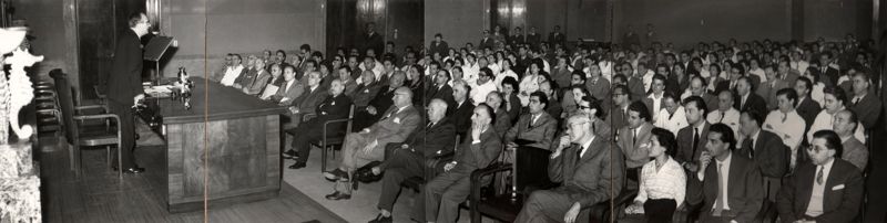 Conferenza del Prof. Héctor Croxatto (lato destro della foto) nell'Aula Magna piena di persone, tra le quali possiamo notare il Prof. Domenico Marotta (seduto in prima fila, settimo da destra) ed il Prof. Giovanni Battista Marini Bettolo Marconi (in prima fila, quarto da destra).