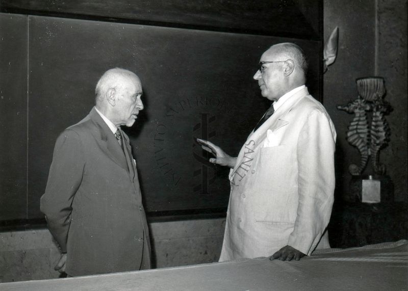 S. E. Giovanni Battista Bertone (lato sinistro) nell'aula magna dell'Istituto Superiore di Sanità  in conversazione con il prof. Domenico Marotta (lato sinistro).