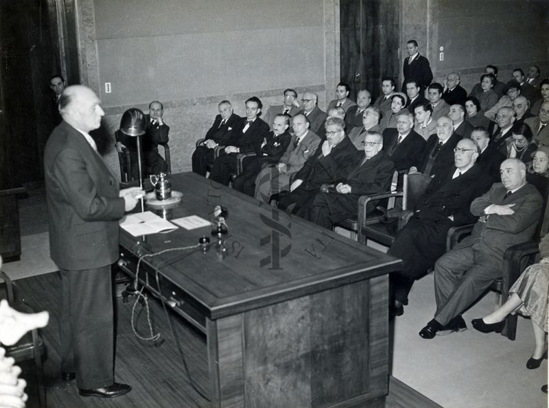 Il Prof. C. Heymaus, in piedi, a sinistra, dietro al tavolo dei relatori, mentre effettua il suo intervento in aula