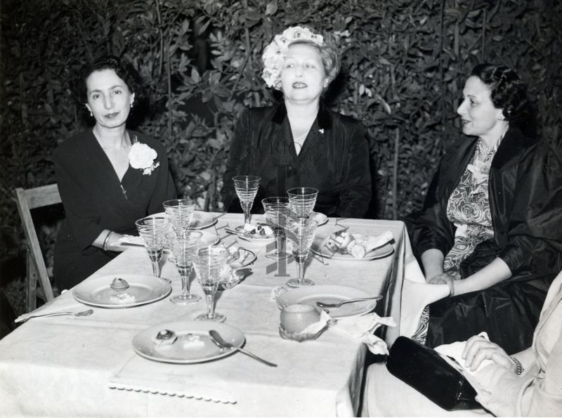 Foto di tre donne seduti ad uno dei tavoli allestiti nel giardino dell'Istituto Superiore di Sanità in occasione del IX Congresso internazionale dell'industria agraria