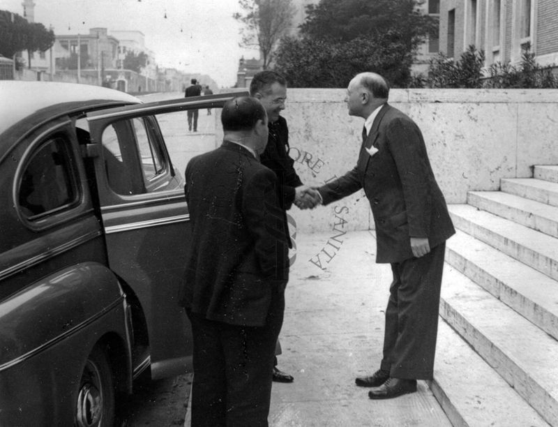 Il prof. D. Marotta (primo sulla destra) saluta tendendo la mano all'Avv. Marchisi (prima di entrare in macchina).