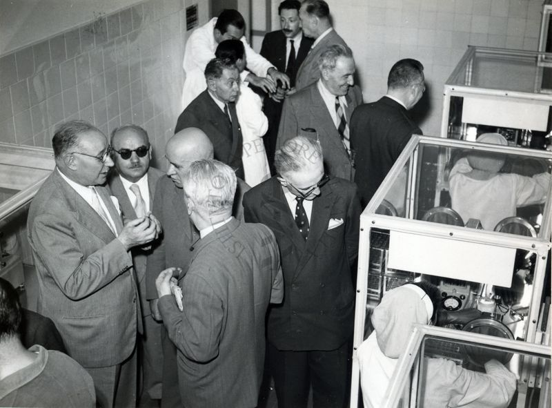 Alcuni dei Senatori in visita all'Istituto Superiore di Sanità ripresi all'interno dei laboratori dell'Istituto. Inquadrati: in primo piano, in basso a sinistra, il Prof. Domenico Marotta, in fondo il Prof. Ernst Boris Chain e, di profilo, il Dr. Massimo Pantaleoni