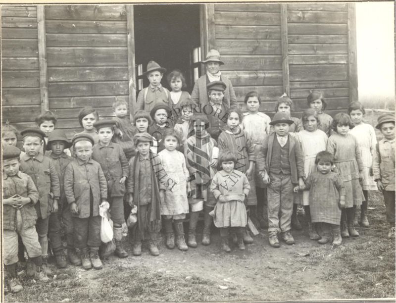 Gruppo di bambini malarici fotografati davanti una baracca-scuola.
