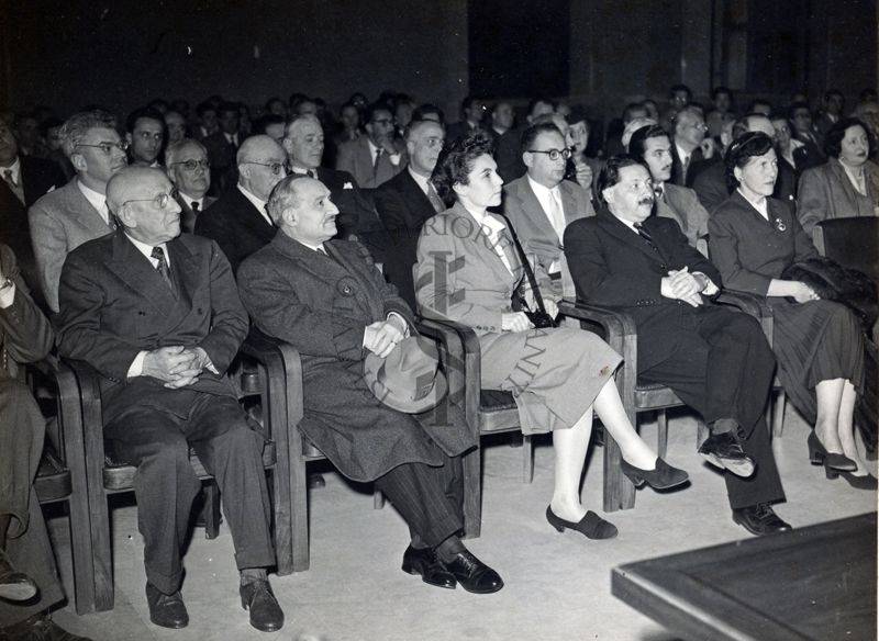 Parte dell'uditorio presente in aula magna in occasione della conferenza tenuta dal Prof. H. Corwin Hinshaw all'Istituto Superiore di Sanità. In prima fila: il Prof. Ernst Boris Chain (secondo da destra) e la Dr.ssa Anne Beloff-Chain (terza da destra). In seconda fila: il Prof. Giovanni Battista Marini Bettolo (primo da sinistra).