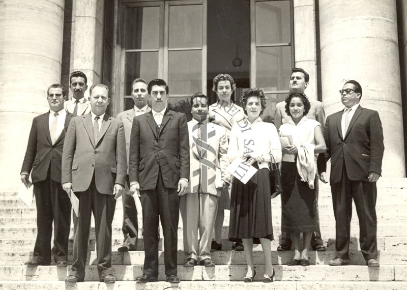 Foto di gruppo di uomini e donne in visita all'Istituto Superiore di Sanità sulle scale dell'ingresso principale