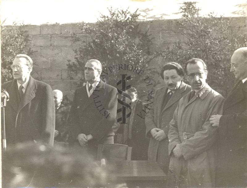 Cerimonia della posa della prima pietra per l'erigendo Istituto della Penicillina. Parla il Presidente del Consiglio on. Alcide de Gasperi, dietro di lui l'Ambasciatore d'America James Clement Dunn, alla sua sinistra il premio Nobel per la medicina e la fisiologia Ernst Boris Chain, segue il prof. Nicola Perotti Alto Commissario per l'Igiene e la Sanità Pubblica, infine il prof. Domenico Marotta