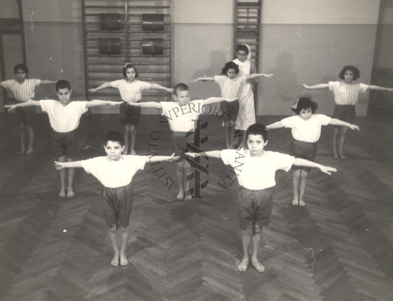 Sala per la ginnastica collettiva dell'Istituto Ortopedico "Luigi Spolverini" di Ariccia (Roma) - un'infermiera controlla la postura di un gruppo di bambini che svolgono esercizi ginnici