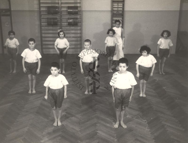 Sala per la ginnastica collettiva dell'Istituto Ortopedico "Luigi Spolverini" di Ariccia (Roma) - un'infermiera controlla la postura di un gruppo di bambini che svolgono esercizi ginnici