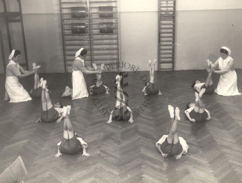 Sala per la ginnastica collettiva dell'Istituto Ortopedico "Luigi Spolverini" di Ariccia (Roma) - delle infermiere controllano la postura di un gruppo di bambini che svolgono esercizi ginnici