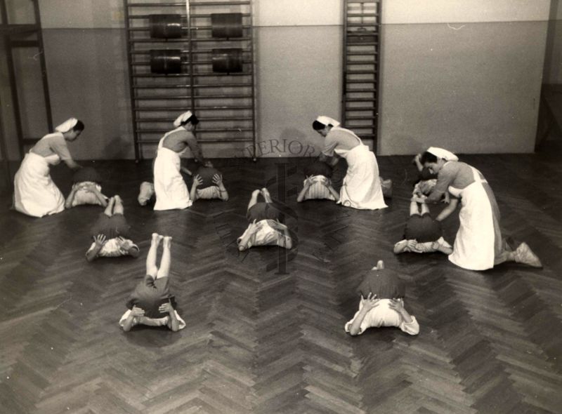 Sala per la ginnastica collettiva dell'Istituto Ortopedico "Luigi Spolverini" di Ariccia (Roma) - delle infermiere controllano la postura di un gruppo di bambini che svolgono esercizi ginnici