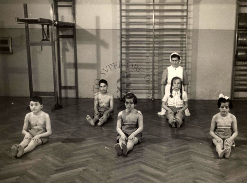 Istituto Ortopedico "Luigi Spolverini" di Ariccia - Bambini che effettuano ginnastica segmentaria per la spalla seguiti da assistenti