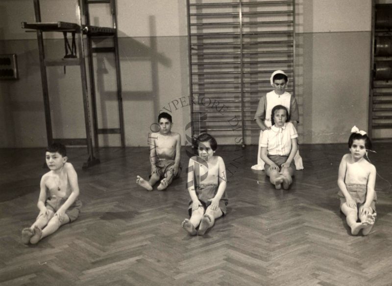 Istituto Ortopedico "Luigi Spolverini" di Ariccia - Bambini che effettuano ginnastica segmentaria per la spalla seguiti da assistenti