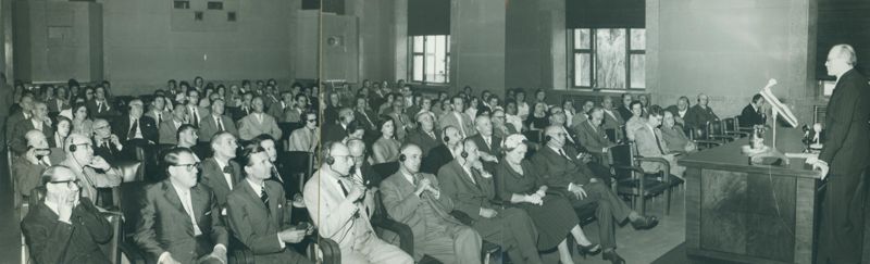 Nella foto i partecipanti alla conferenza svolta in Aula Magna, sulla destra il Prof. Percy Cyril Claude Garnham e tra il pubblico sono riconoscibili, in prima fila, il Prof. Domenico Marotta; in seconda fila: il Prof. Daniel Bovet e la Dr.ssa Filomena Nitti