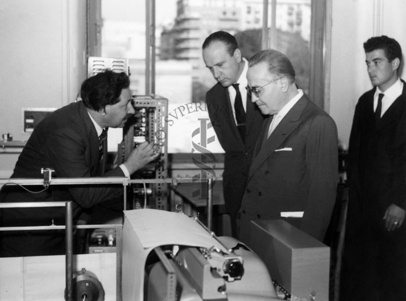 Visita in uno dei laboratori dell'Istituto Superiore di Sanità, sono presenti, il Prof. Ernst Boris Chain che parla con il Ministro della Sanità Vincenzo Monaldi, ed altri