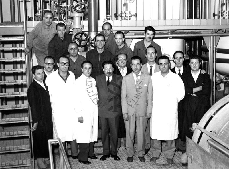 Foto di gruppo del Personale Sanitario e tecnico del Laboratorio di Chimica Biologica all'interno della fabbrica della Penicilina dell'Istituto Superiore di Sanità con il Prof. Boris Chain