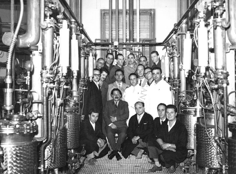 Foto di gruppo del Personale Sanitario e tecnico del Laboratorio di Chimica Biologica all'interno della fabbrica della Penicilina dell'Istituto Superiore di Sanità con il Prof. Boris Chain