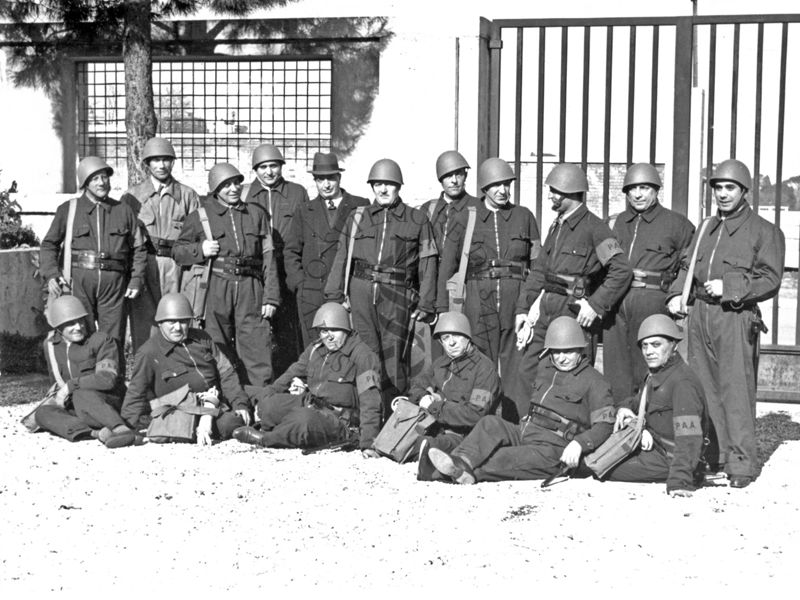 Foto di gruppo della squadra pompieristica all'interno del giardino dell'Istituto di Sanità Pubblica