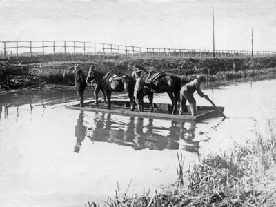 Militi della C.R.I. in servizio antimalarico, mentre su di un traghetto traversano un fiume